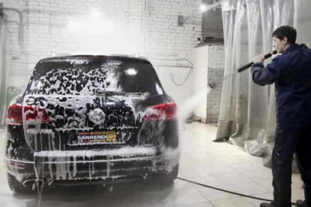 мойщик моет автомобиль